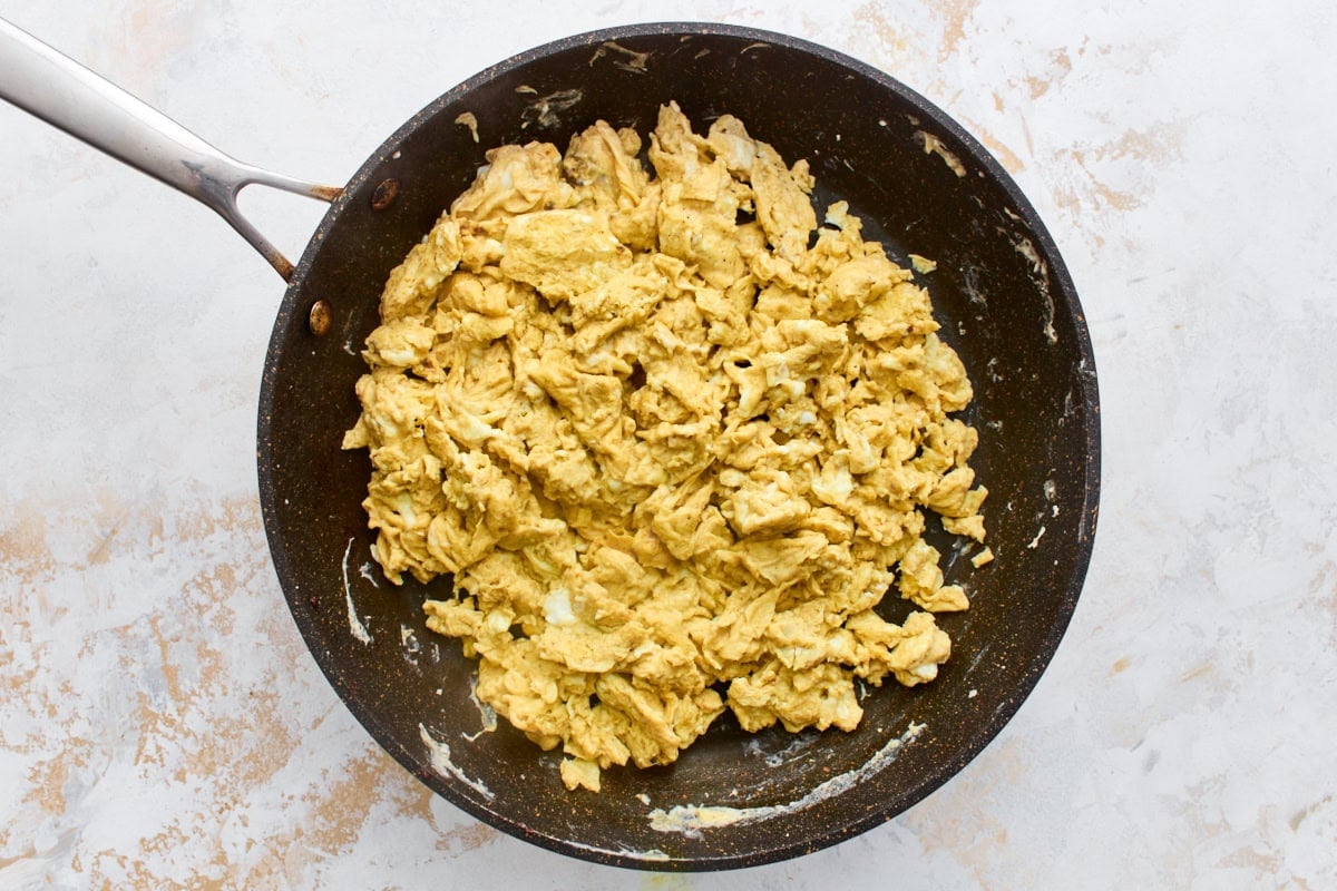 Soft scrambled eggs cooked low and slow in a skillet for gluten-free breakfast burritos
