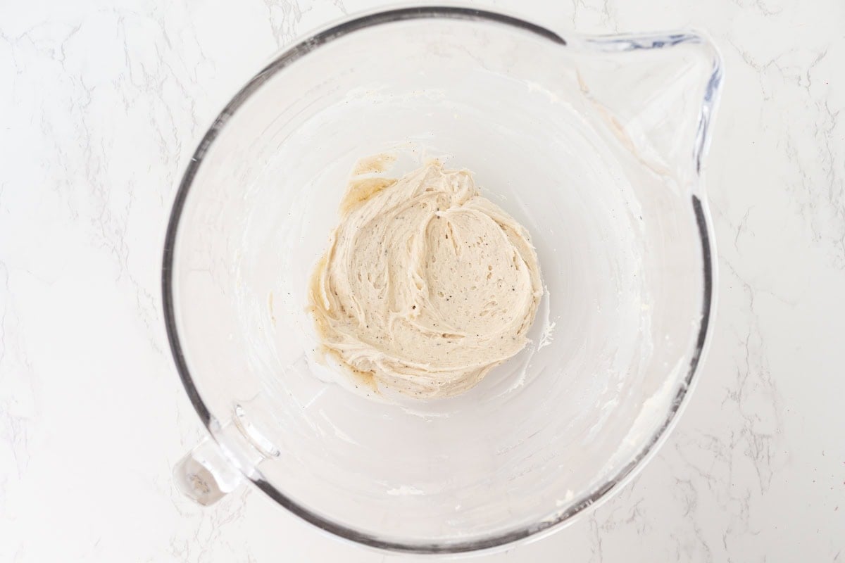 Brown butter cream cheese frosting whipped smooth in a stand mixer bowl.