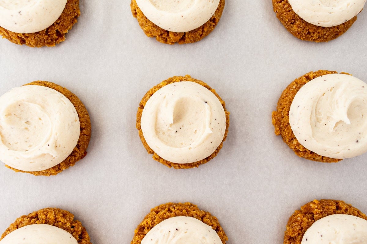 Overhead view of gluten-free almond flour pumpkin cookies topped with brown butter cream cheese frosting.