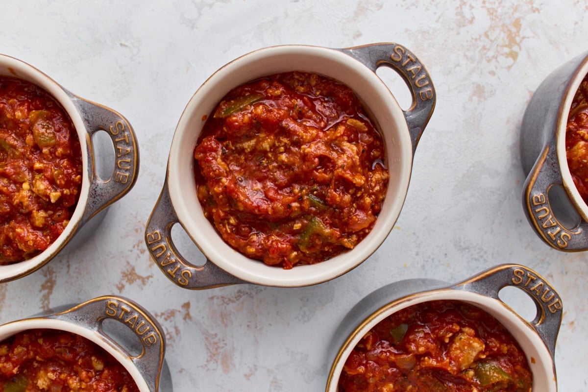 Sausage and marinara filling divided into five mini ramekins for crustless pizza bowls.